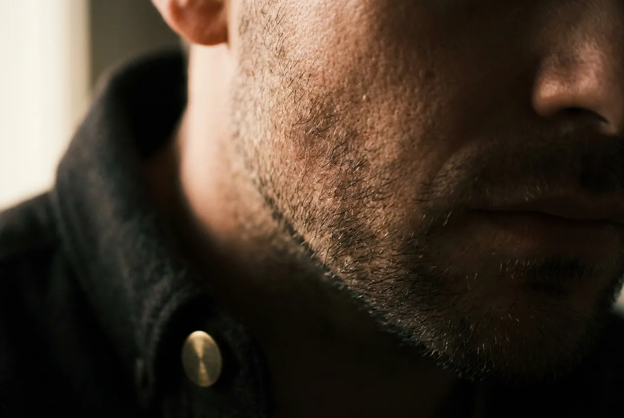 Macro de la mejilla de un hombre con barba de dos días, con sus poros y su textura: la piel que trata un peeling químico
